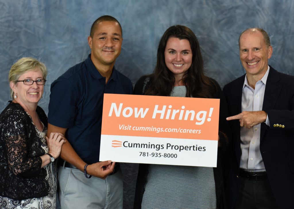 Cummings Team Holding Hiring Sign